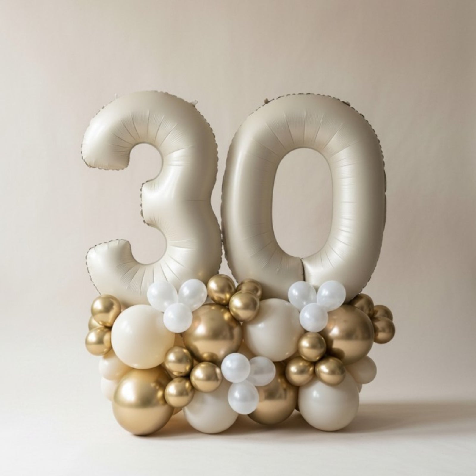 Balloon arrangement with number '30' on a plain background